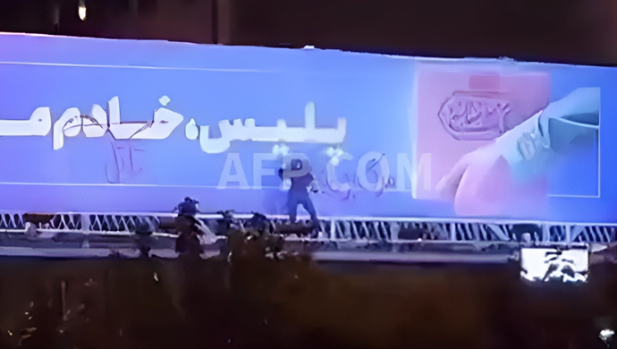 A.F.P: تدمير لوحة اعلانية كبيرة للنظام الايراني بشعار "قاتل" و"الموت لخامنئي"