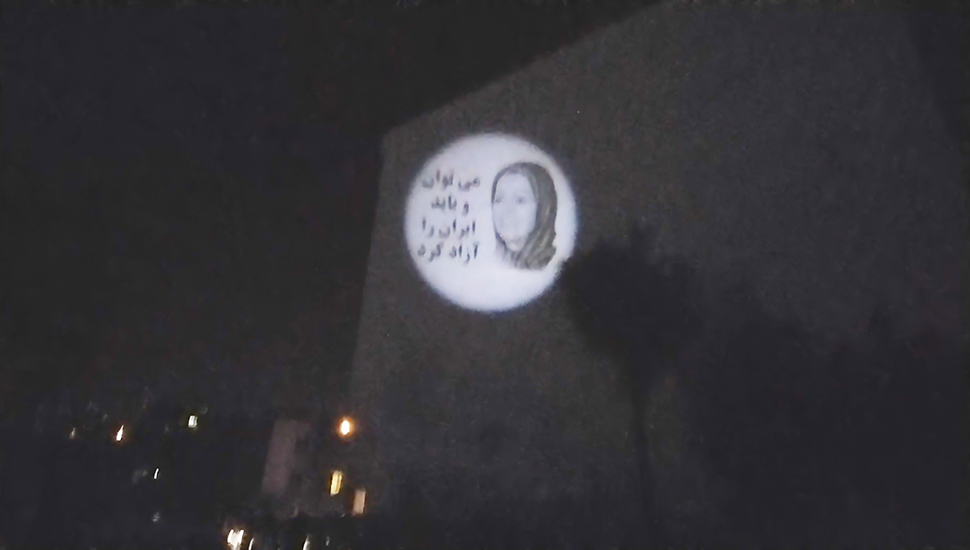 صورة ضوئية للسيدة مريم رجوي وشعار"يمكن ويجب تحرير إيران" في طهران