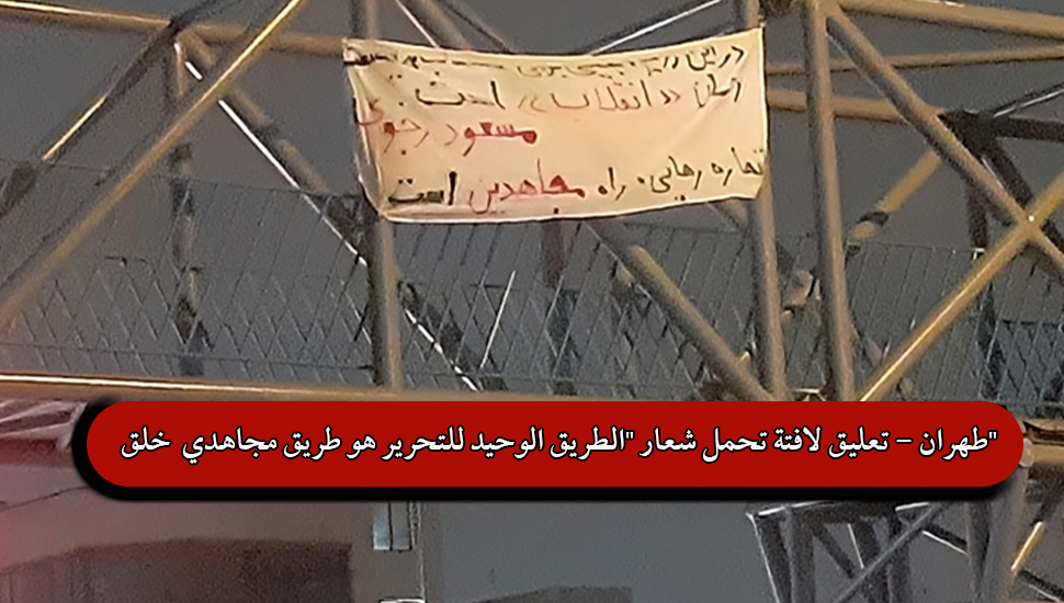 طهران - تعليق لافتة تحمل شعار "الطريق الوحيد للتحرير هو طريق مجاهدي خلق"