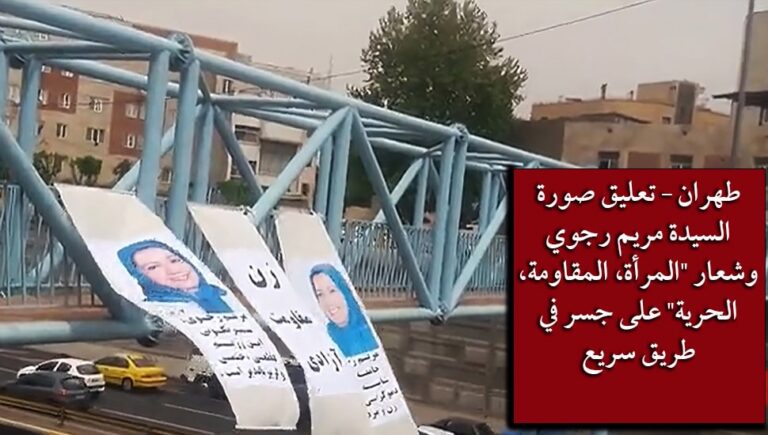 طهران – تعليق صورة السيدة مريم رجوي وشعار “المرأة، المقاومة، الحرية” على جسر في طريق سريع