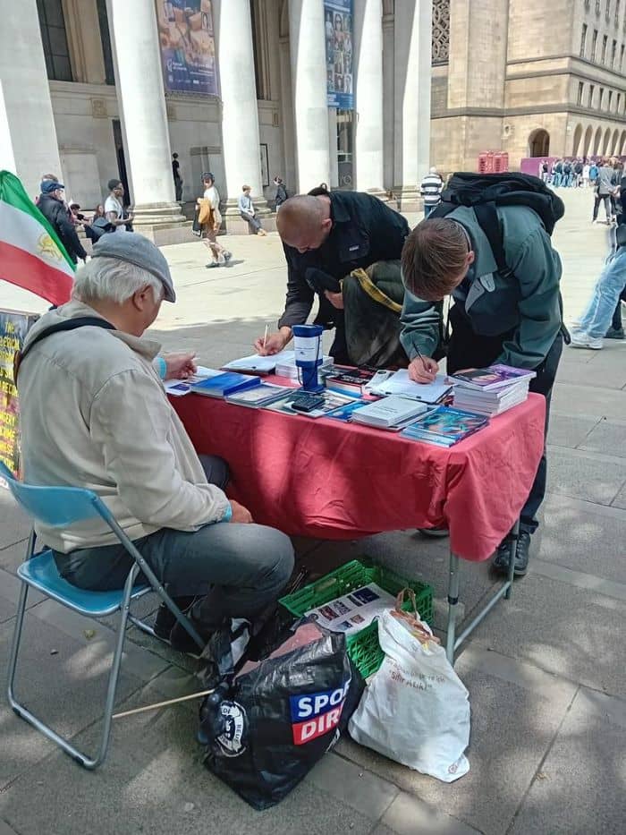مانشستر، بريطانيا - طاولة كتب ومعرض لصور شهداء الانتفاضة الإيرانية