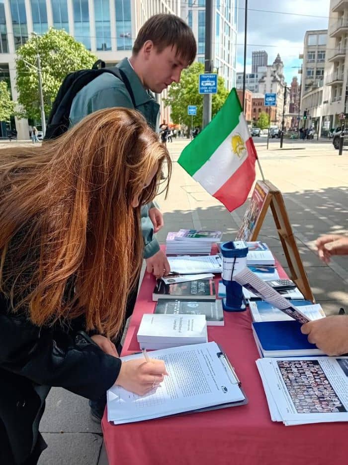 مانشستر، بريطانيا - طاولة كتب ومعرض لصور شهداء الانتفاضة الإيرانية